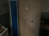 un placard situé dans un coin d'une pièce, avec une porte bleue