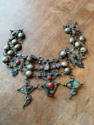 an image of a close up of a necklace on a wooden surface