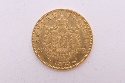gros plan d'une pièce d'or sur une surface blanche