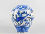 a blue and white vase with a bird on it