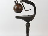 sculpture représentant un oiseau, avec une lampe posée sur la tête, posé sur une table