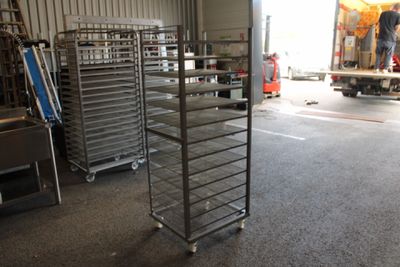 une étagère métallique sur laquelle sont posés plusieurs plateaux de nourriture
