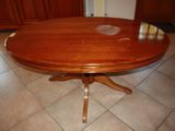 a wooden table with a glass top on a tile floor
