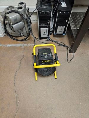 un petit compresseur d'air posé par terre à côté d'un ordinateur