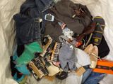 a pile of clothes and shoes on a bed