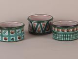 three small cups with designs on them are sitting on a table