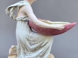 statue of a woman holding a bowl on top of a base