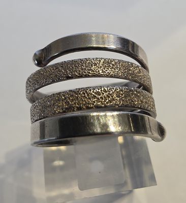 un gros plan sur un bracelet en argent surmonté d'un anneau métallique