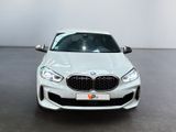 a white bmw m140i parked in a showroom