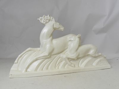 a white sculpture of a deer and a dog on a hill