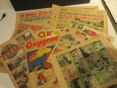 de nombreuses bandes dessinées posées sur une table, avec un ordinateur portable en arrière-plan
