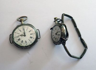 deux types différents de montres de poche posées sur une surface blanche