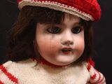 a doll that is wearing a red and white sweater and hat