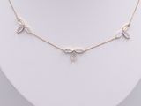a gold necklace with three moonss and a diamond on a mannequin
