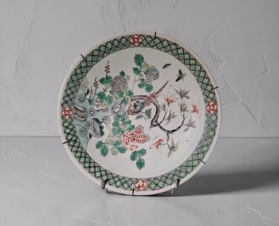 une assiette blanche ornée d'un motif vert et rouge