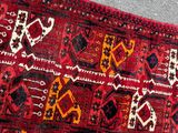 a red rug on the floor next to a wall