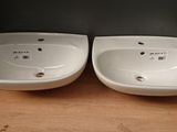 two white sinks sitting on top of a wooden shelf