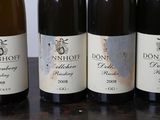 four bottles of wine are lined up on a table