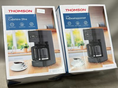 deux cartons contenant des machines à café posés sur une table
