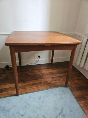 une petite table en bois avec un tapis bleu posé par terre