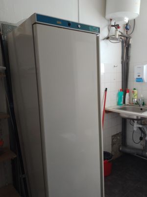 a refrigerator in the corner of a kitchen with a sink