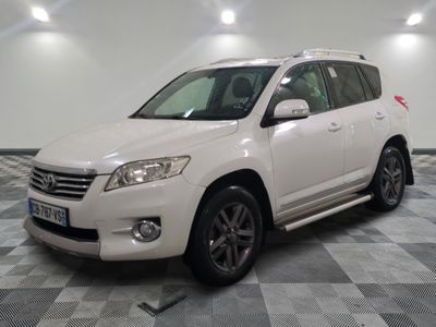 the white toyota suv is parked in a large room