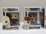 two harry potter pop vinyl figures in their boxes on a table
