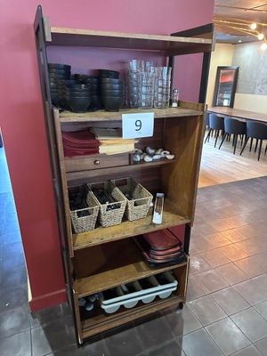 une étagère sur laquelle sont posés de la vaisselle et des verres, dans une pièce