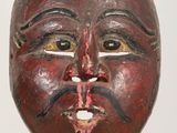 an old wooden mask on a stand with a white background