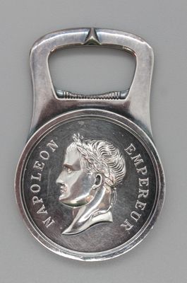 un décapsuleur en forme de pièce de monnaie sur laquelle est représenté le visage d'un homme