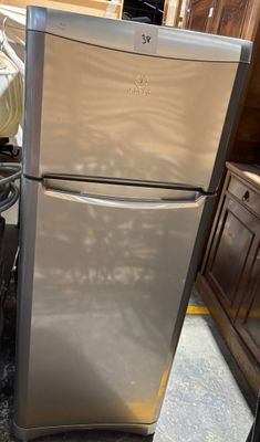 a stainless steel refrigerator in a kitchen with wood cabinets