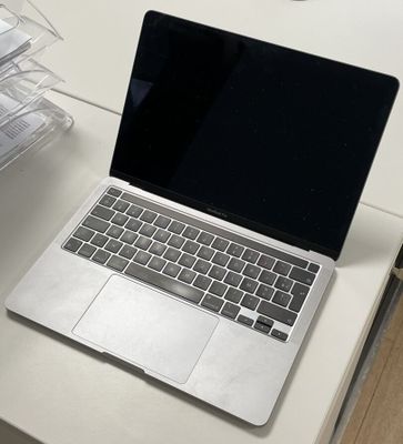 un ordinateur portable posé sur un bureau blanc