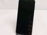 the back of a black cell phone sitting on top of a white table