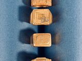 trois anneaux en or portant des inscriptions égyptiennes sur un fond bleu