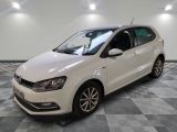 the white volkswagen polo is parked in a large room with checkered flooring