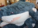 un grand requin en peluche posé sur un lit