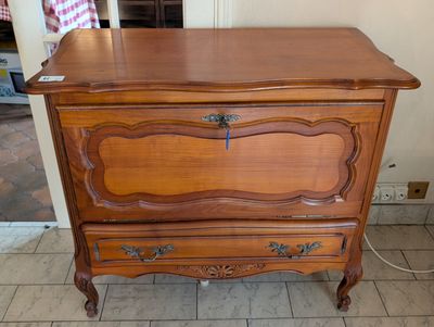 a wooden chest of drawers that is in a room