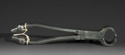 a metal pliers on a table with a black background