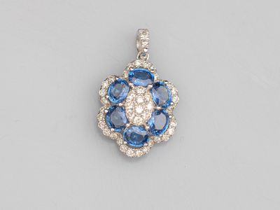 an 18k white gold diamond and blue sapphire pendant