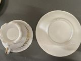 two cups and saucers sitting on a table next to each other