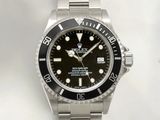 une montre Rolex avec un cadran noir et un bracelet argenté