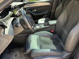the interior of a car with the door open and the driver ' s seat down