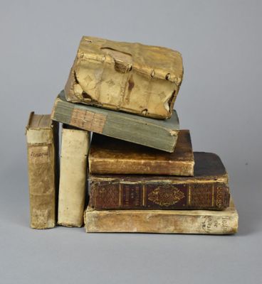 plusieurs vieux livres empilés les uns sur les autres sur une surface grise