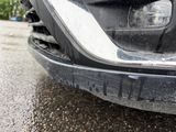 a close up of the front bumper of a car with mud on it