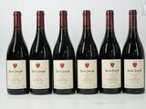 six bouteilles de vin sont alignées sur une table