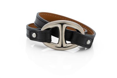 un gros plan sur un bracelet en cuir noir muni d'une boucle en argent