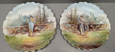 two decorative plates with a painting of a couple on them