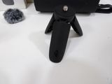 a black video camera sitting on a table next to a black bag