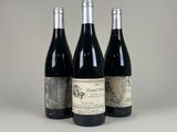 trois bouteilles de vin sont alignées sur une table