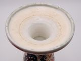 a white vase with a red and blue design on it